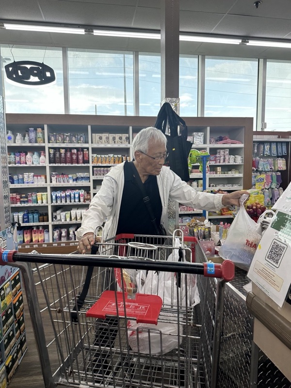 Dr. Ji shopping for healthy food, selecting produce at a store